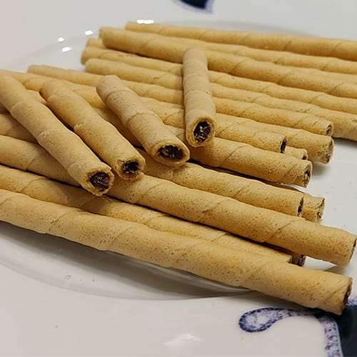 Preview: Barquillos rellenos de almendra 200g - waffle rolls filled with hazelnut cream Preview: Waffle rolls filled hazelnut cream on a plate